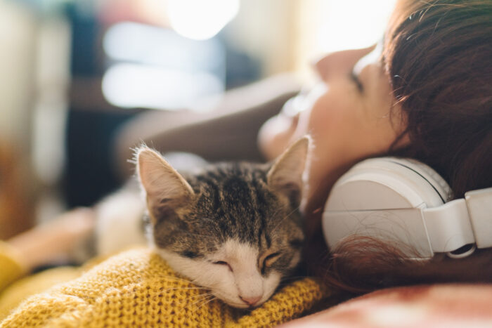 Relaxed girl with cat listening to music